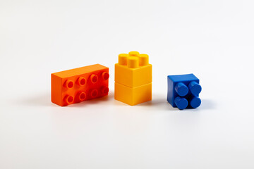 Multicolored blocks of the children's constructor lie on a white background