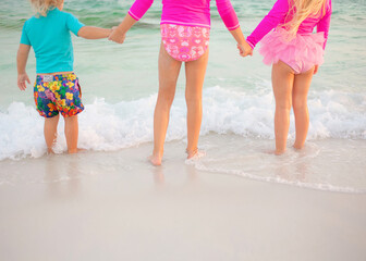 Family on beach at sunset with surfboard guitar