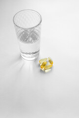 Oliecapsules (zachte capsules) of voedingssupplementen: visolie, omega-3, omega-6, omega-9, vitamine A, vitamine D3, vitamine E, teunisbloemolie, bernagiezaadolie. Gele zachte capsules op een witte ac