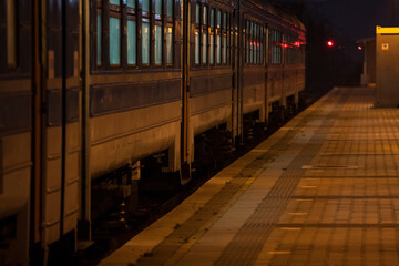 Selective blur on the doors of a suburban train of a commuter train station of Belgrade, Serbia, on an empty platform, at night. - obrazy, fototapety, plakaty