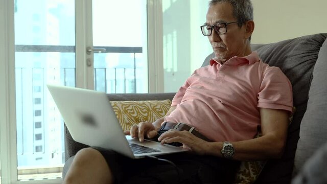 Technology concept, senior citizen using laptop at home.