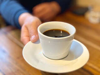 コーヒーを差し出す男性の手