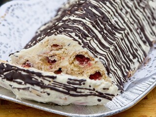 Traditional Russian cake Monastery Hat with sour cherries and white cream, covered with chocolate drizzle