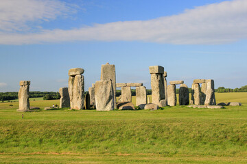 Naklejka premium Stonehenge in the late afternoon with blue sky and green grass 