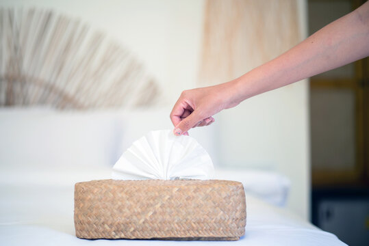 woman hands pulling white tissue paper from wooden box,Protect your hands with a tissue