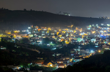 Night scene in the valley bright houses with colorful lights makes the night scene in the countryside more vibrant in the Da Lat plateau, Vietnam