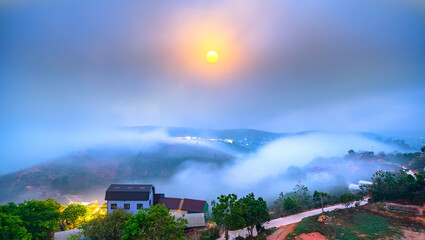 Dawn on plateau in morning with colorful sky, while sun rising from horizon shines down to small...