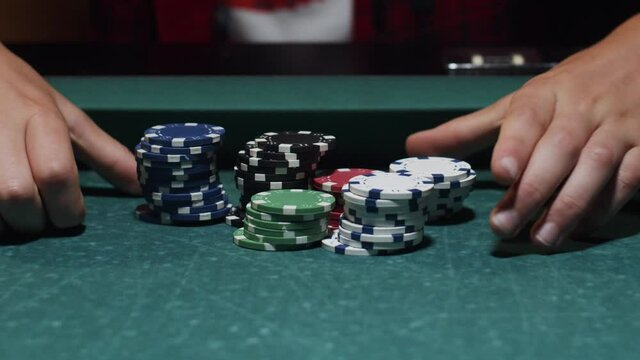 Poker chips push in with hands on table