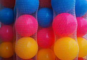 Many colors plastic balls in a mesh bag.
