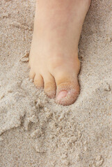 Feet of little boy on sand. Child having fun on the beach
