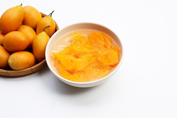 Marian plum fruits in syrup with ice in white bowl on white