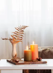 Fotobehang burning candles with autumn decor on white table at home © Maya Kruchancova