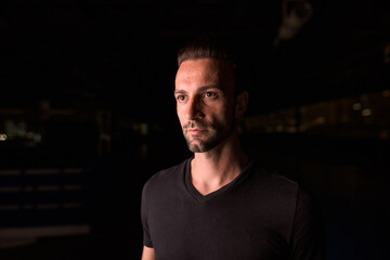 Obraz premium Portrait of handsome man thinking at night in parking lot building