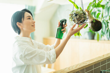 出勤前に観葉植物に水をやる女性
