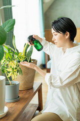出勤前に観葉植物に水をやる女性