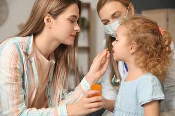 Obraz na płótnie Canvas Pediatrician examining little girl at home