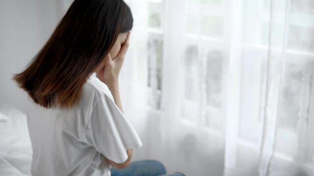 Psychologist touches a depressed Asian woman for encouragement. Woman crying and then friend's hand came to her shoulder to comfort and encourage.