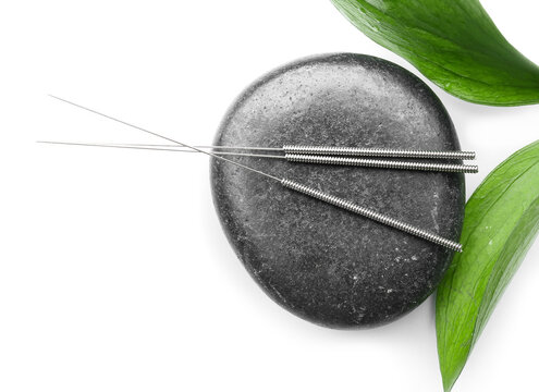 Acupuncture Needles And Spa Stone On White Background