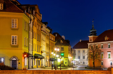 Evening panorama of Castle Square with colorful tenement houses and Kanonia street in Starowka Old Town historic district of Warsaw, Poland