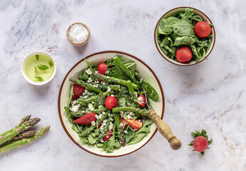 A healthy and delicious salad made from fresh strawberries, green asparagus, feta cheese with...