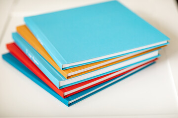 pyramid of multicolored books or photo albums. Place for the inscription. selling photographer's services or printing.