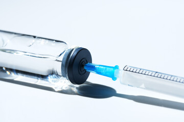 Close up glass vial with flu vaccine and syringe with needle. The concept of vaccination or...