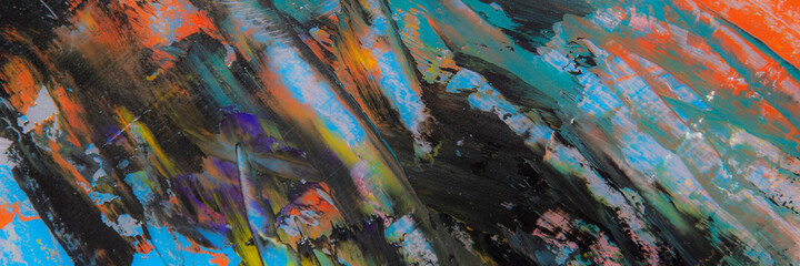 colorful creative motley background: smudged residues of oil paints on a wooden palette, short focus, selective blur