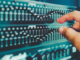 Black equalizer sound lever with multiple stems arranged in a wave pattern With the hands of the agitator in front Colorful Taken from a lateral angle, concept Sound Engineer, Sound adjustment.