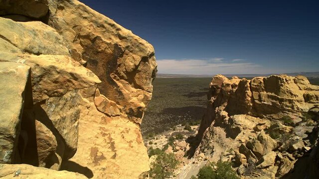 Sandstone Bluffs, El Malpais National Monument in the desert of New Mexico is a dramatic landscape made of Dakota Sandstone that contrasts with the dark lava flows farther below. Distant horizon.