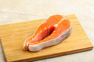 Raw salmon steak over board