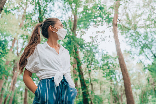 Walking In Nature Woods Wearing Face Mask During Coronavirus Pandemic. Asian Woman In Sustainable Eco Friendly Clothing Fashion Fabric. People Lifestyle Sustainability Concept.