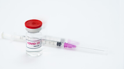 Covid-19 vaccine, clear glass vials, syringes placed next to each other, white background, copy space concept covid-19