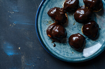 Profiterole, powdered sugar on a blue background