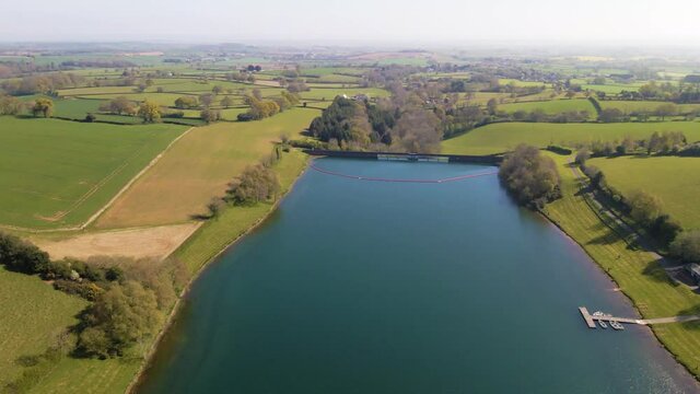 4K flying over hawkridge reservoir, drone moving forward over the water revealing the fishing boats docks and the water dam wall, 60fps.