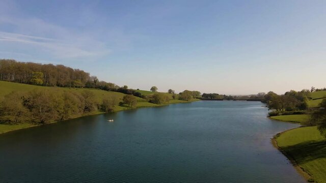 4K flying over hawkridge reservoir, drone moving to the left over the water revealing the fishing boats docks and the water dam wall, 60fps.