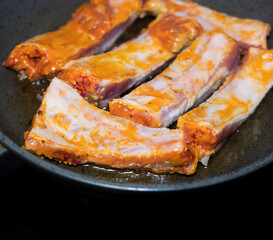 
Pork ribs meat close-up in a frying pan