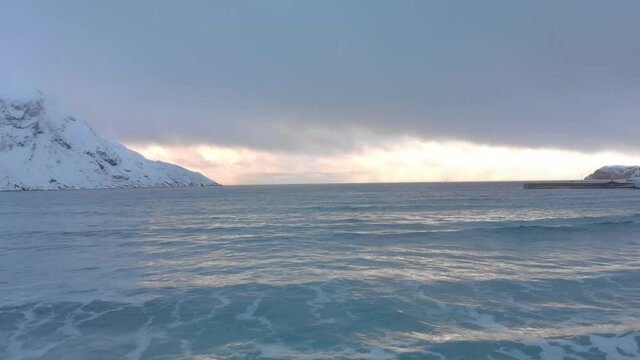 Aerial push in sunset out in the sea in breathtaking Hoddevik Norway
