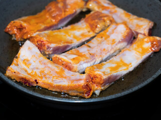 
Pork ribs meat close-up in a frying pan