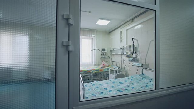 Modern hospital room with two beds. Intensive care unit. Empty clean reanimation room with new medical equipment. View from the hospital corridor.