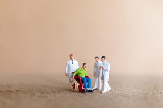 Miniature people , Patient in wheelchair consulting with doctor, medical healthcare concept.