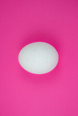 White egg on the pink background. Copy space. Minimalism, original and creative photo. Beautiful wallpaper. Easter holidays.