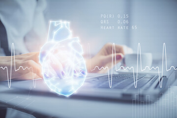 Double exposure of woman hands typing on computer and heart hologram drawing. Education concept.