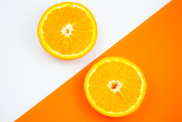 Close up photo of Orange Fruit on the white and orange background. Citrus cut in half, inside, macro view. Minimalism, original and creative image. Beautiful natural wallpaper.