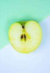 Close up photo of Green Apple Fruit on the white and green background. Minimalism, original and creative image. Beautiful natural wallpaper.