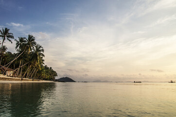 sunset on the sandy beach of a tropical island.