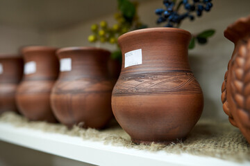 A set of clay vases stands on the counter in the store