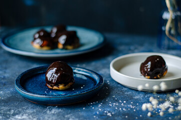Profiterole, powdered sugar on a blue background