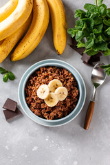 Raw oatmeal porridge with banana and chocolate. Top view