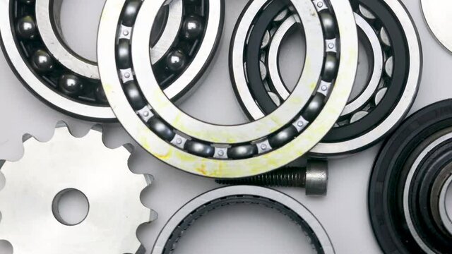 Bearings on a white background, spinning in a circle. The use of bearings and gears in production.