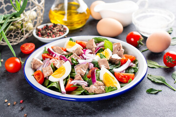 Salad from cod liver, eggs and vegetables on a plate. Nutritious, useful.